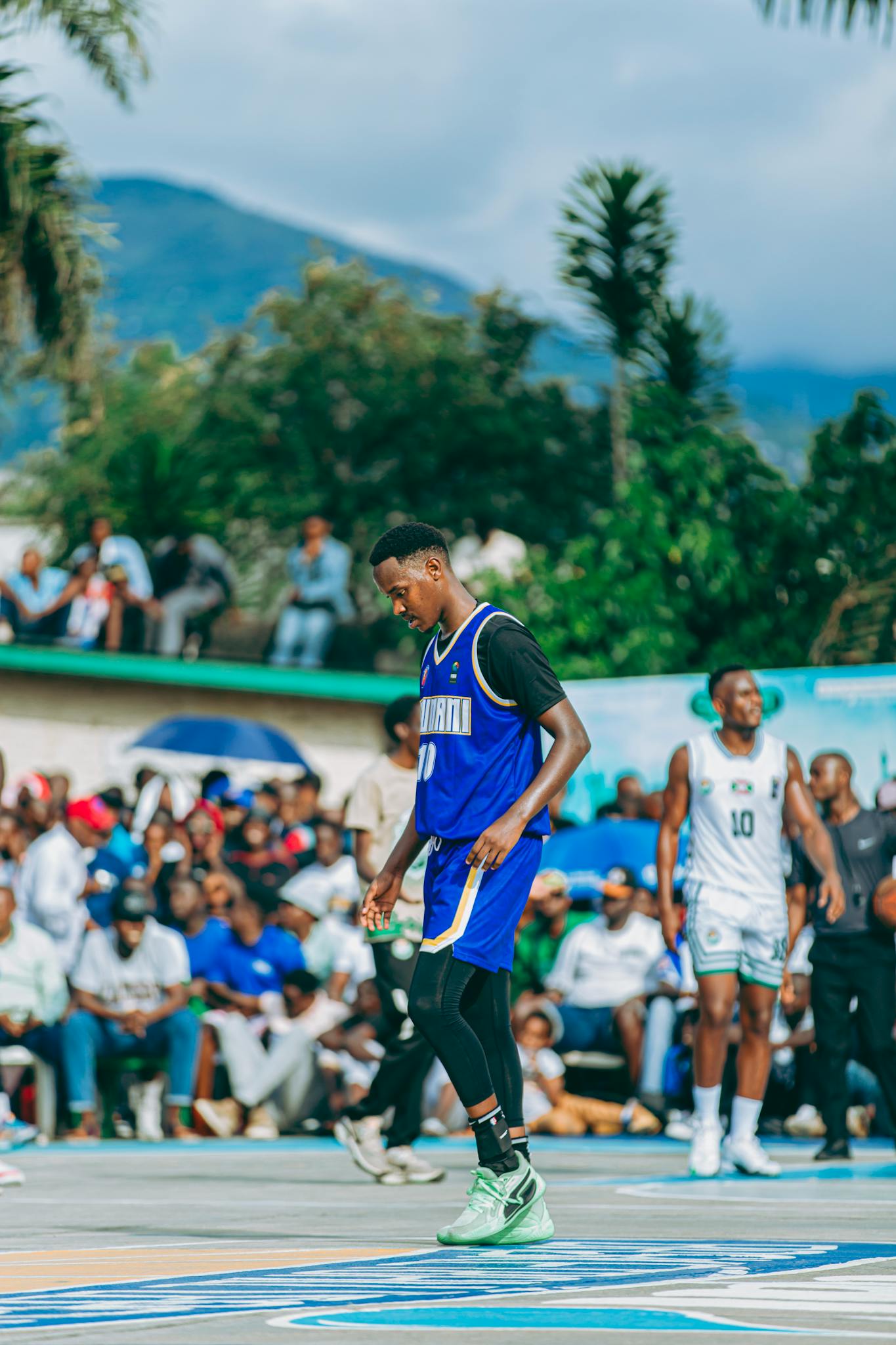 Dynamic outdoor basketball game featuring local teams in vibrant Bujumbura setting.