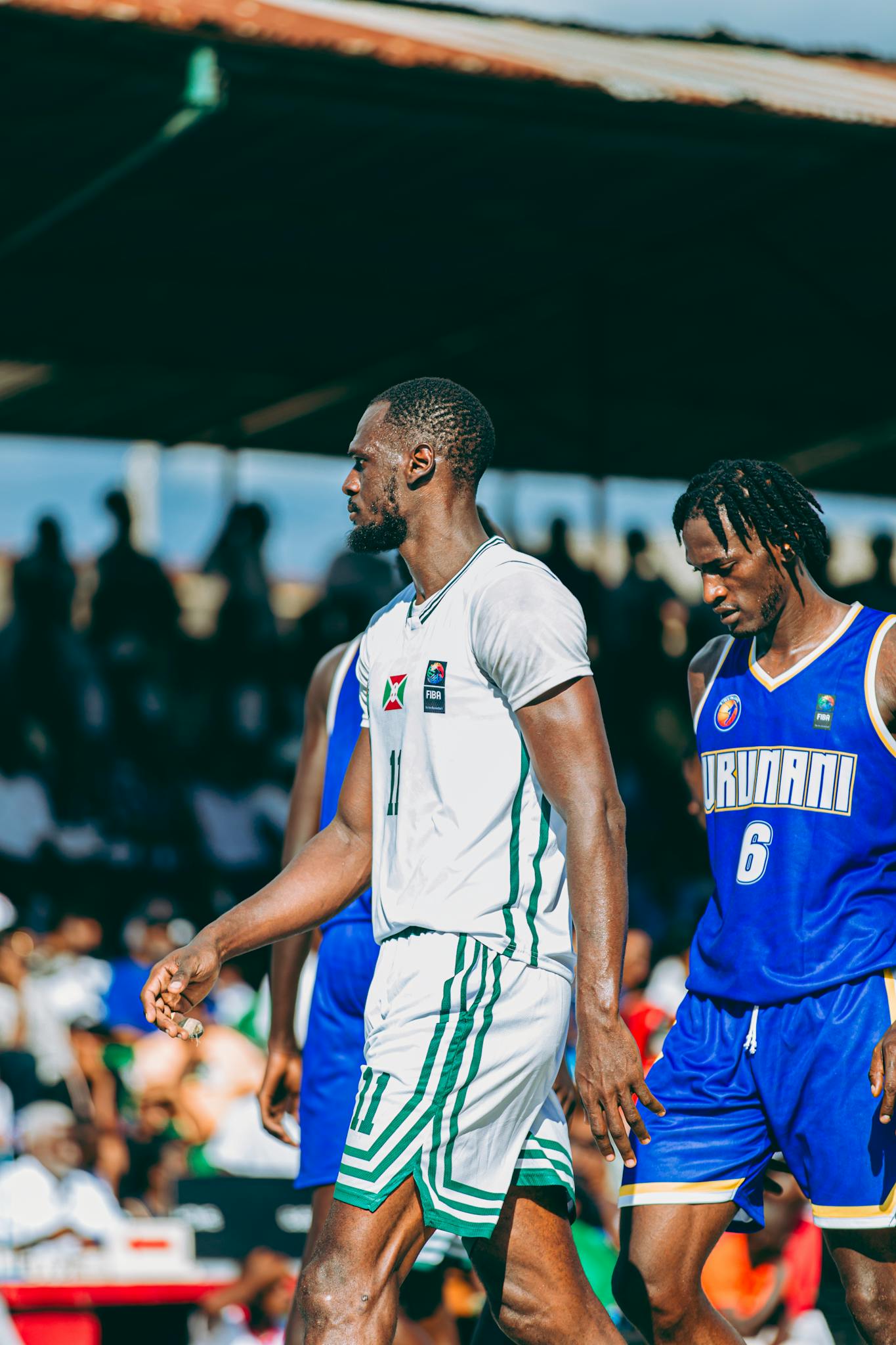 Outdoor basketball match with players competing energetically on a sunny day.