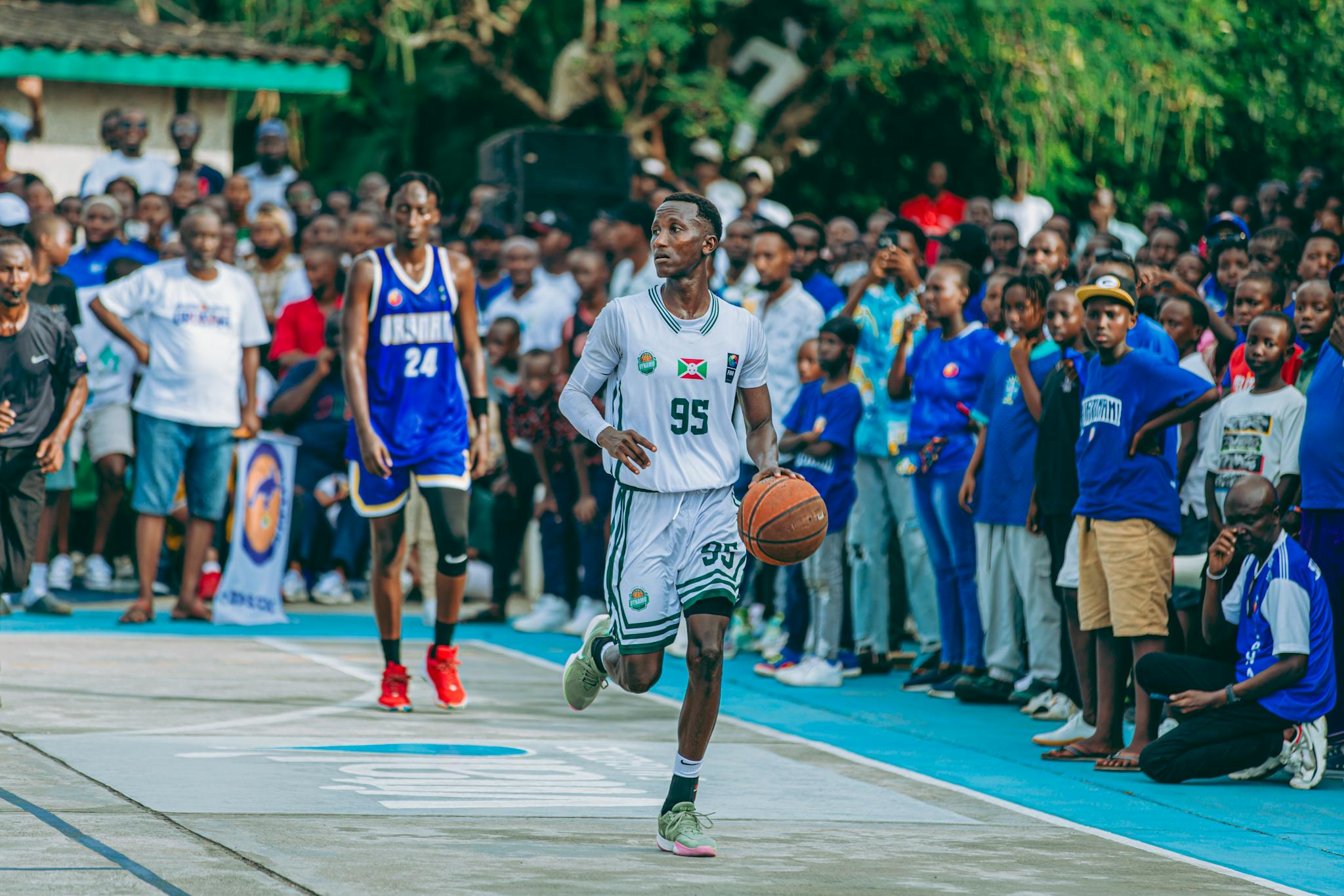 Vibrant street basketball game with diverse players and enthusiastic crowd.